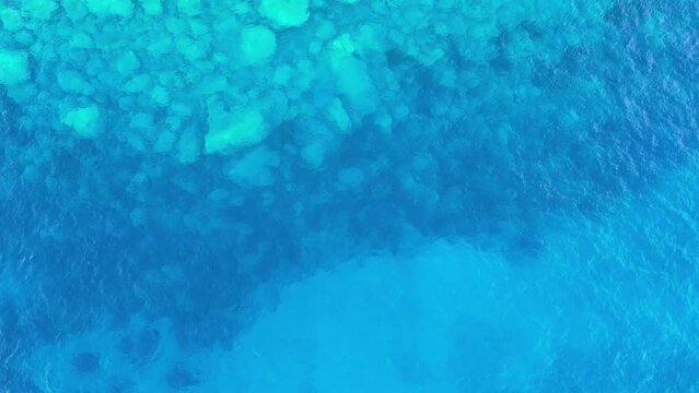 Abstract background of deep sea waves and stones, water ripples. Diving into the clear blue sea