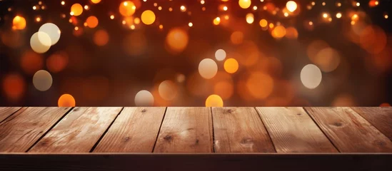 Foto op Canvas A wooden table illuminated by Amber Automotive lighting with a blurry background of Christmas lights. The Wood table adds warmth to the scene, creating a cozy ambiance for the event © AkuAku
