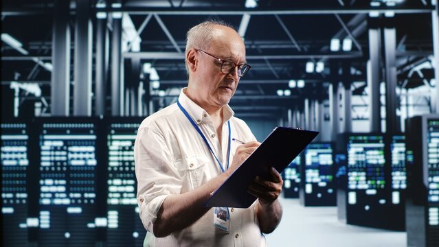 Skilled IT professional expertly managing data while navigating in industrial server room. Expert ensuring flawless cybersecurity protection, optimizing systems and perform necessary updates