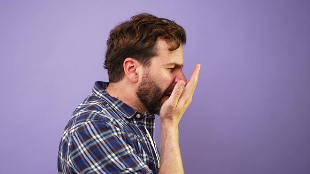Man using his hand to check his breath and discovering he has a really bad smell