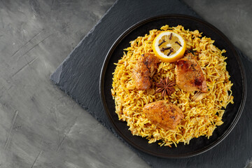 Chicken Biryani with Spices on Black Plate, Indian Cuisine Concept, Top View, Copy Space