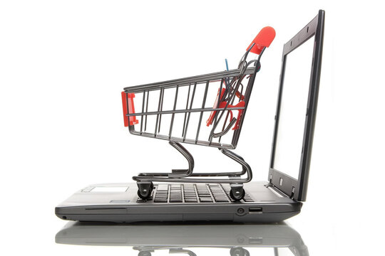 shopping-cart over a laptop isolated on white