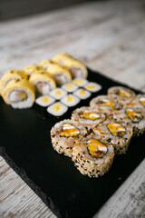 Assorted japanese sushi rolls on black background.