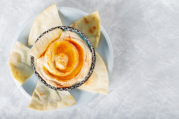 Chickpea Hummus Bowl and Pita on Gray Concrete Background, Copy Space, Top View
