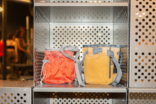 Two colorful backpacks on metal locker shelf