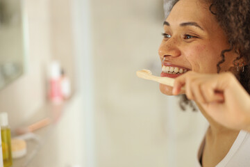 a woman is brushing her teeth in front of a mirror in a bathroom