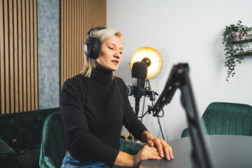 short-haired blond Caucasian woman working on a live podcast, medium shot. High quality photo