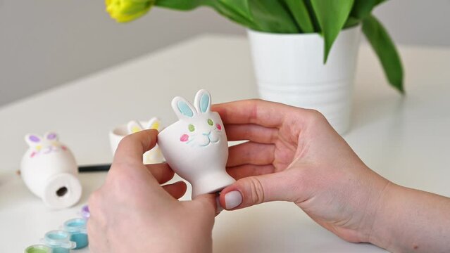  Woman preparing for spring holiday and painting handmade egg holders for easter