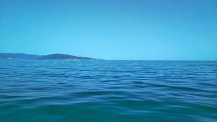 An ideal serene seascape - on the distant horizon the blue clear sky and the blue calm sea...