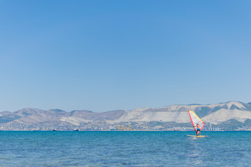 A man is engaged in windsurfing at sea, summer sea holidays, active recreation at sea