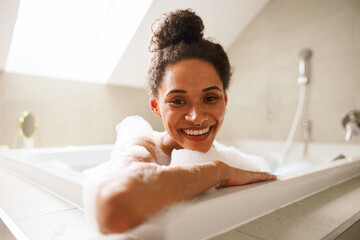 The woman is happily bathing in a jacuzzi tub, smiling with joy