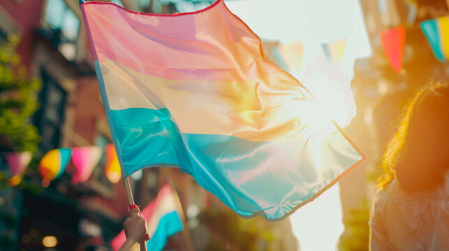 female hand holding lgbt flag with blurred background