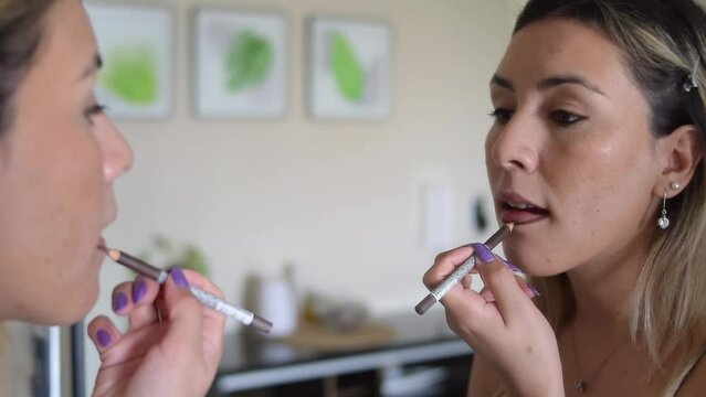 close-up woman putting on makeup in front of a mirror