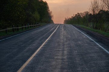 A hazy sunrise over a country road in the spring