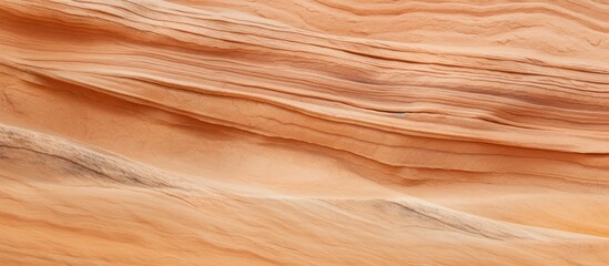 Fototapeta premium A close up of a sand dune in the desert, showcasing a beautiful blend of brown, amber, peach, and beige hues. Just like a hardwood flooring ingredient made of plywood and wood