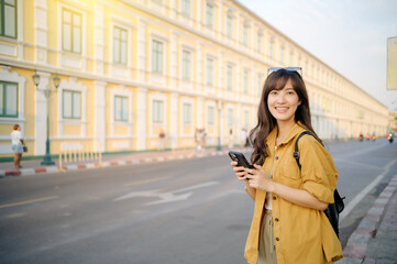 Traveler asian woman in her 30s using smartphone for navigation destination on the urban street at Bangkok, Thailand.