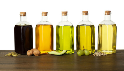 Vegetable fats. Bottles of different cooking oils and ingredients on wooden table against white background