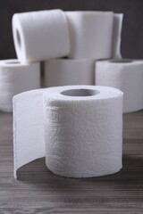 Soft toilet paper rolls on wooden table, closeup
