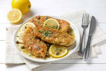 Delicious chicken piccata served on white table