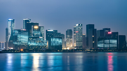 Modern City Skyline Reflecting on Water at Night