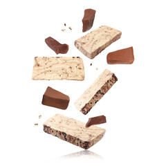 Pieces of tasty halva and chocolate falling on white background