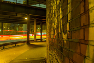 Abstract depiction of traffic lights illuminating the night road, with car light trails streaking...