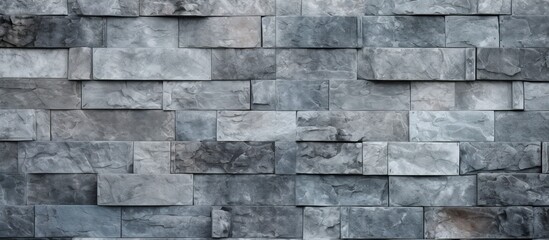 A detailed closeup of a rectangular grey brick wall showcasing the intricate brickwork pattern. The building material contrasts nicely with the wood flooring