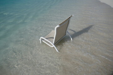 Chair in the ocean with clear water