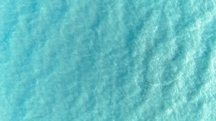Sea aerial view. Top view of the sea water with the waves of the crashing onto the shore....