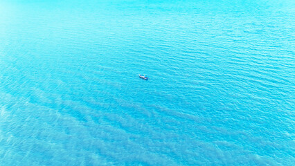 Aerial view boat on the sea. Top view, fishing boats sailing on the beautiful blue-sky sea. ​​summer With a boat floating in the middle of the sea, filled with relaxation and traveling during holiday 