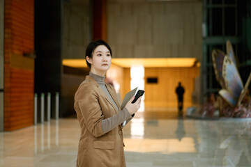 Professional Woman with Tablet in Corporate Lobby
