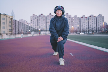 Young Athlete Warming Up on Urban Track at Dusk