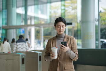 Young Professional Woman Using Phone with Coffee