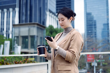 Young Professional Using Smartphone with Coffee on-the-go