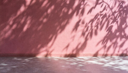 Pink wall adorned with the shadow of a tree under sunlight creates a serene and visually appealing scene. 