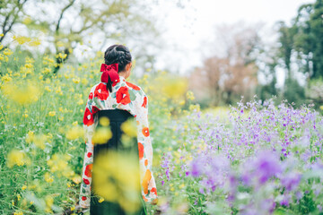 お花畑で袴を着ている少女の後ろ姿
