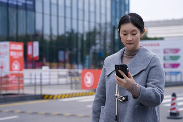 Professional Woman Checking Phone in Urban Setting