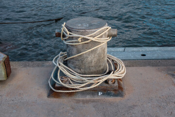 Photograph of white rope wrapped around a steel boat mooring bollard on King Island in the Bass...