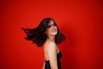 Beauty asian girl Beautiful Asian girl shaking hair isolated on red background.