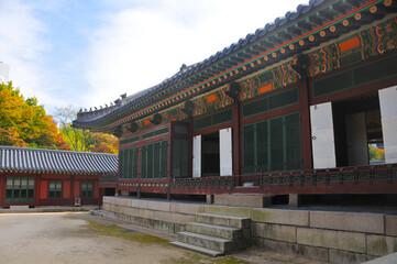 SEOUL, SOUTH KOREA - OCTOBER 26, 2022: Old ancient palace halls for servants inside Deoksugung palace with colourful trees foliage in Autumn.