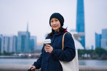 Obraz premium Young Woman Enjoying Coffee in Urban Cityscape