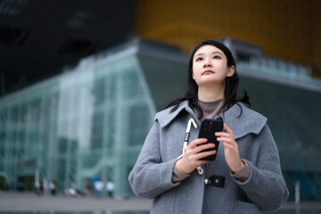 Fototapeta premium Young Woman Concentrated on Mobile in City
