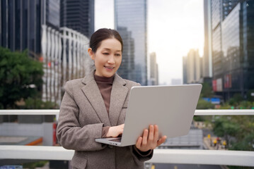 Professional Woman Using Laptop in City Environment