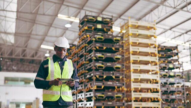 Warehouse workers hand holding digital tablet checking inventory management packaging boxes. Black african man walking in storehouse counting box goods on shelves