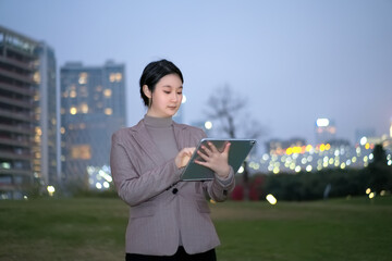 Professional Woman Using Tablet in Evening Urban Park