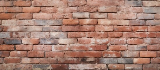 Obraz premium A detailed closeup of a brown brick wall showcasing the intricate brickwork done by a skilled bricklayer. The rectangular bricks are held together by mortar, creating a sturdy composite material