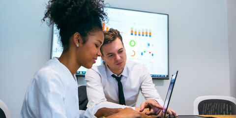 Group of marketing professionals having a meeting. Creative business team brainstorming with sticky notes. Happy business people putting their ideas together as they plan a project.