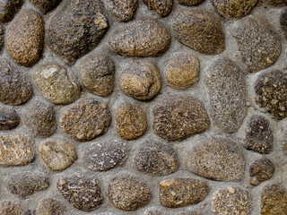 Close-up Stone Wall Texture Background with Gray Pebbles and Rocks on Beach