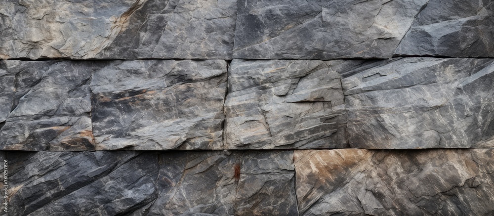 Poster a closeup of a grey stone wall made of bedrock with rectangular composite material pieces creating a