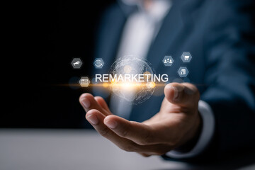 Obraz premium Remarketing concept. Reaching the target audience that has previously visited the website through advertising. Businessman holding globe with remarketing icon on virtual screen.